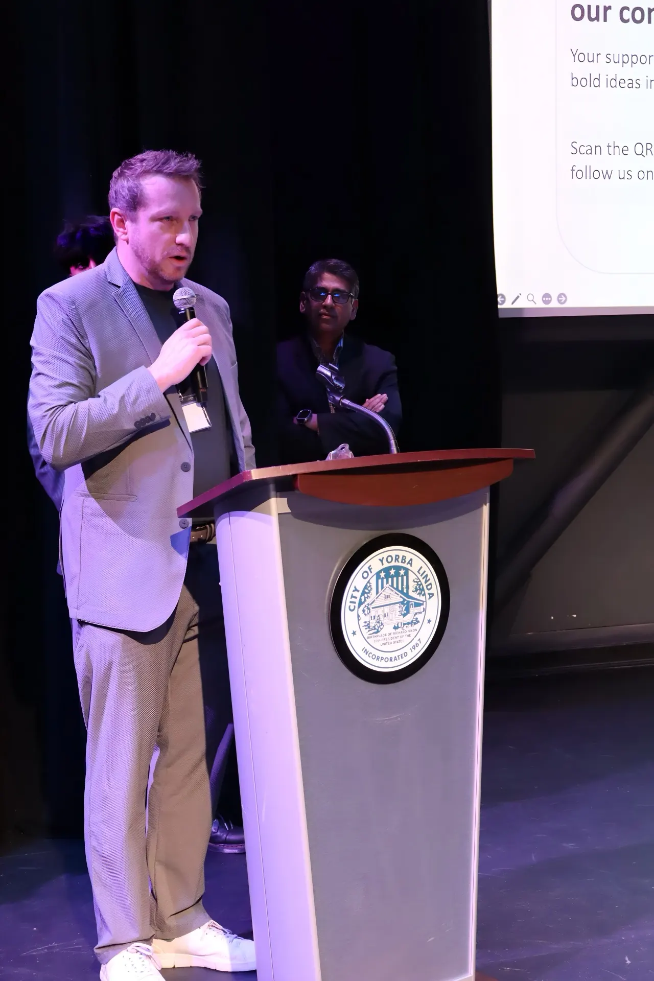Speaker at the Virginia De Land Theater podium, City of Yorba Linda.